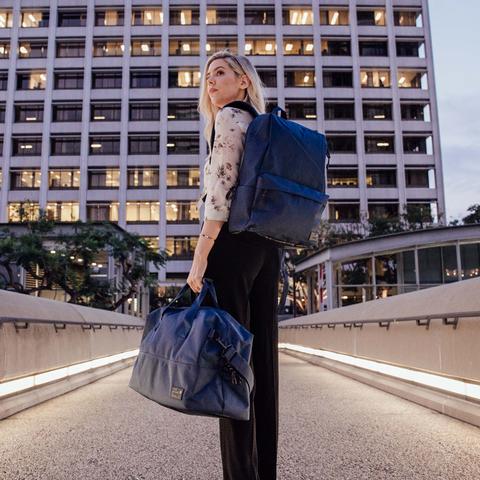 Man carrying HEX Aspect Exile Solid Navy Backpack