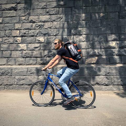 Man wearing HEX Adventure Armenia 30L Backpack, while riding a bike