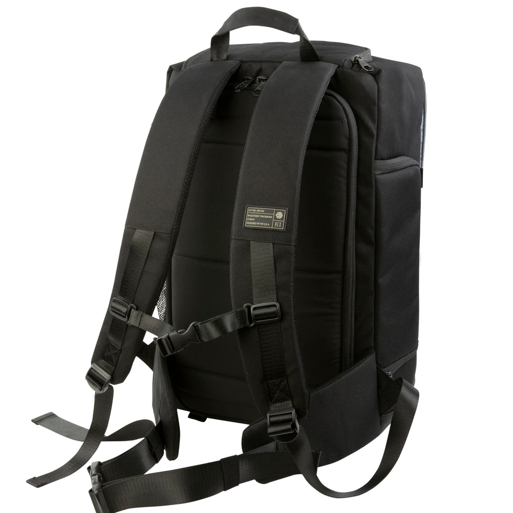 Back view of the Hex Black Cinema Backpack showing the padded shoulder straps, carry handle, and chest and waist tightening straps