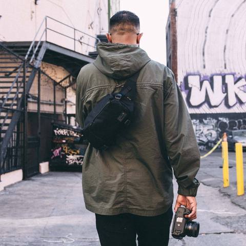 Man wearing Ranger Black DSLR Mini Sling on his back