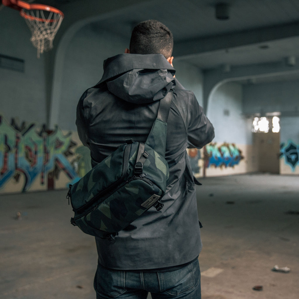 Man wearing HEX Ranger Camo DSLR Sling on his back